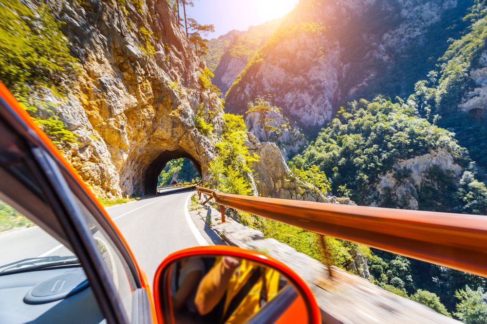 Automobil prolazi kroz tunel na planinskom putu u Crnoj Gori